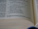 Close-up of a hand flipping through a thick technical reference book.