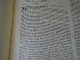 A close-up of a Bible open to a specific section, with text focused on Ezekiel chapter 20. The page displays verses about rebellion and judgment with bold headings.