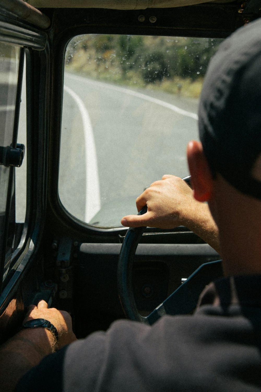 a man driving a bus down a road