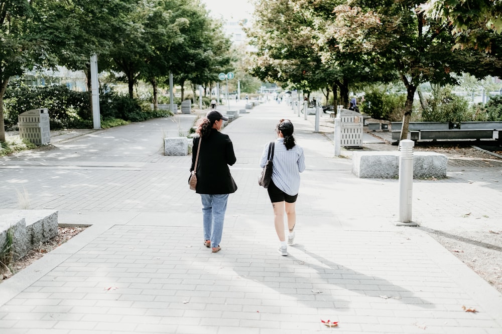 a couple of women walking down a sidewalk