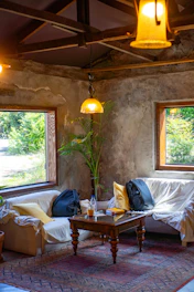 Cozy and sunlit corner of a rustic vacation home surrounded by greenery and warm earth tones.