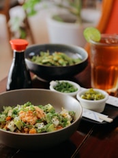 a wooden table topped with bowls of food