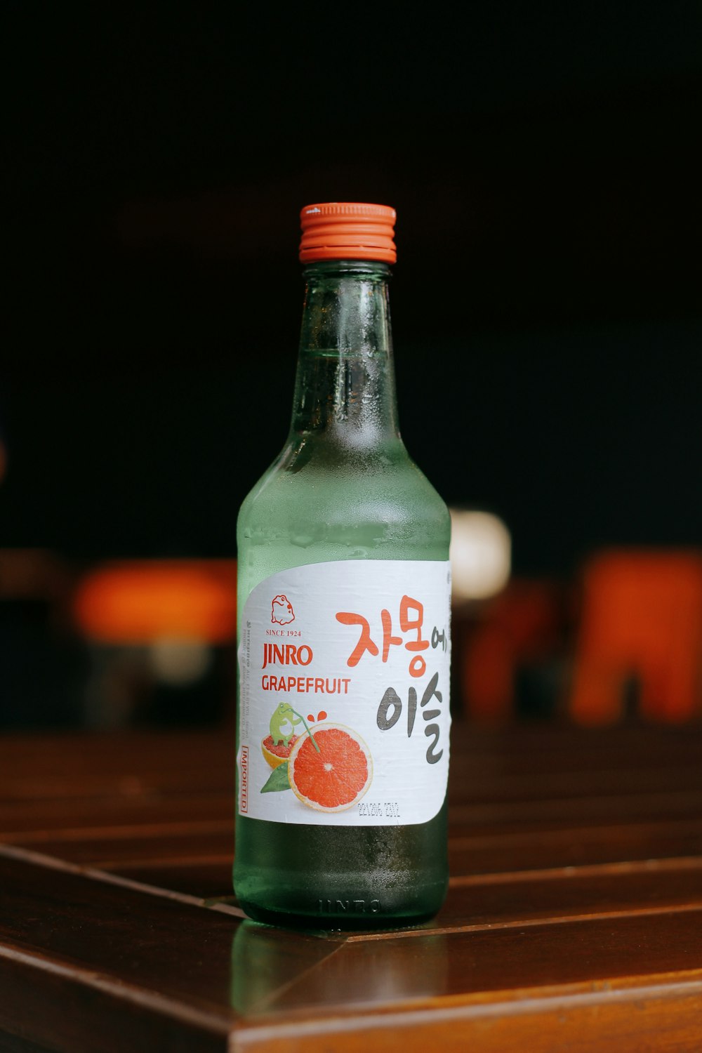 a bottle of green liquid sitting on top of a wooden table