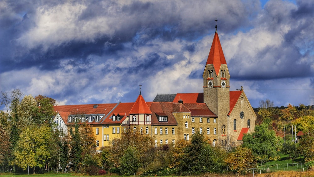 a large building with a red steeple on a cloudy day