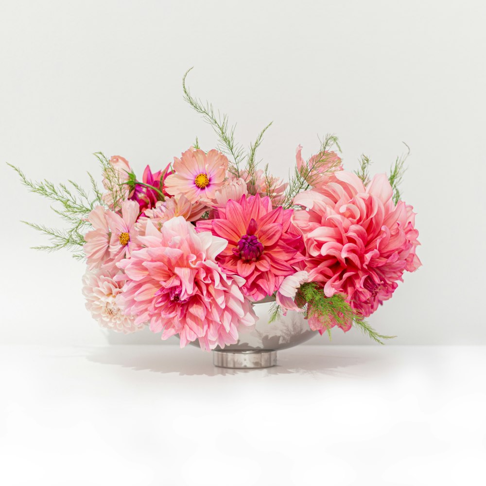 a vase filled with pink flowers on top of a table