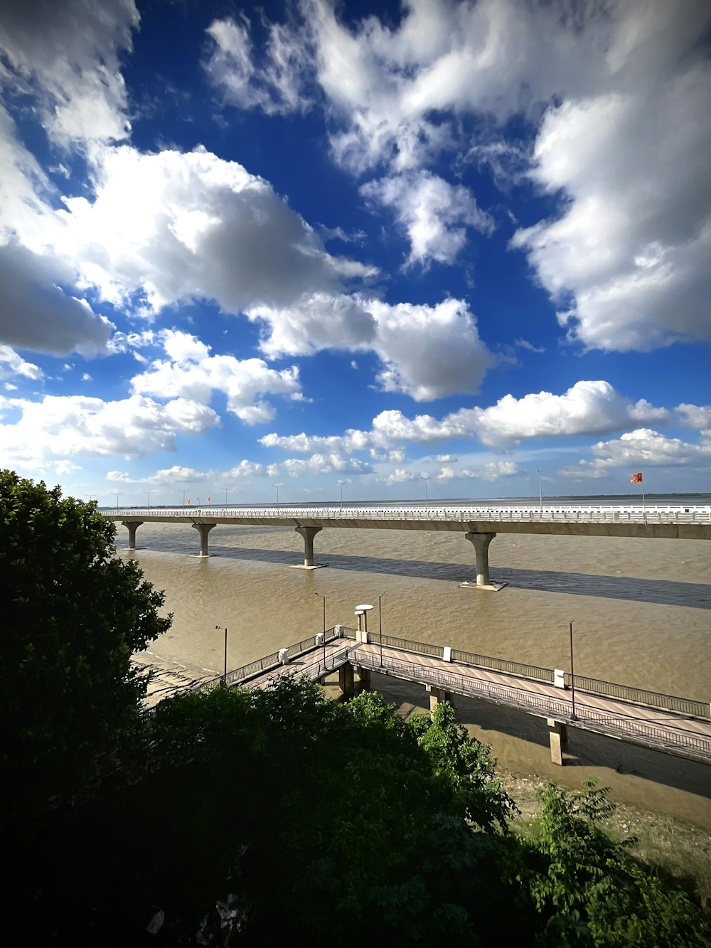 a bridge over a body of water under a cloudy blue sky