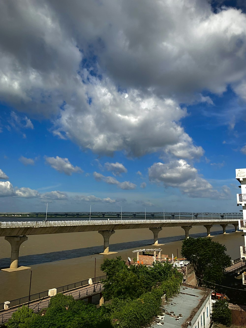 a bridge over a body of water under a cloudy blue sky