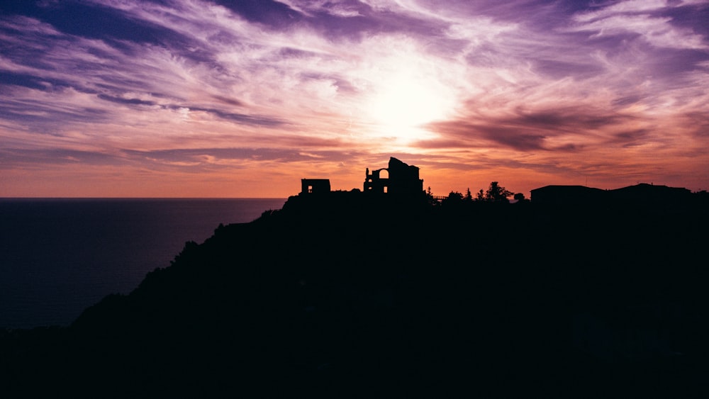 a silhouette of a building on top of a hill