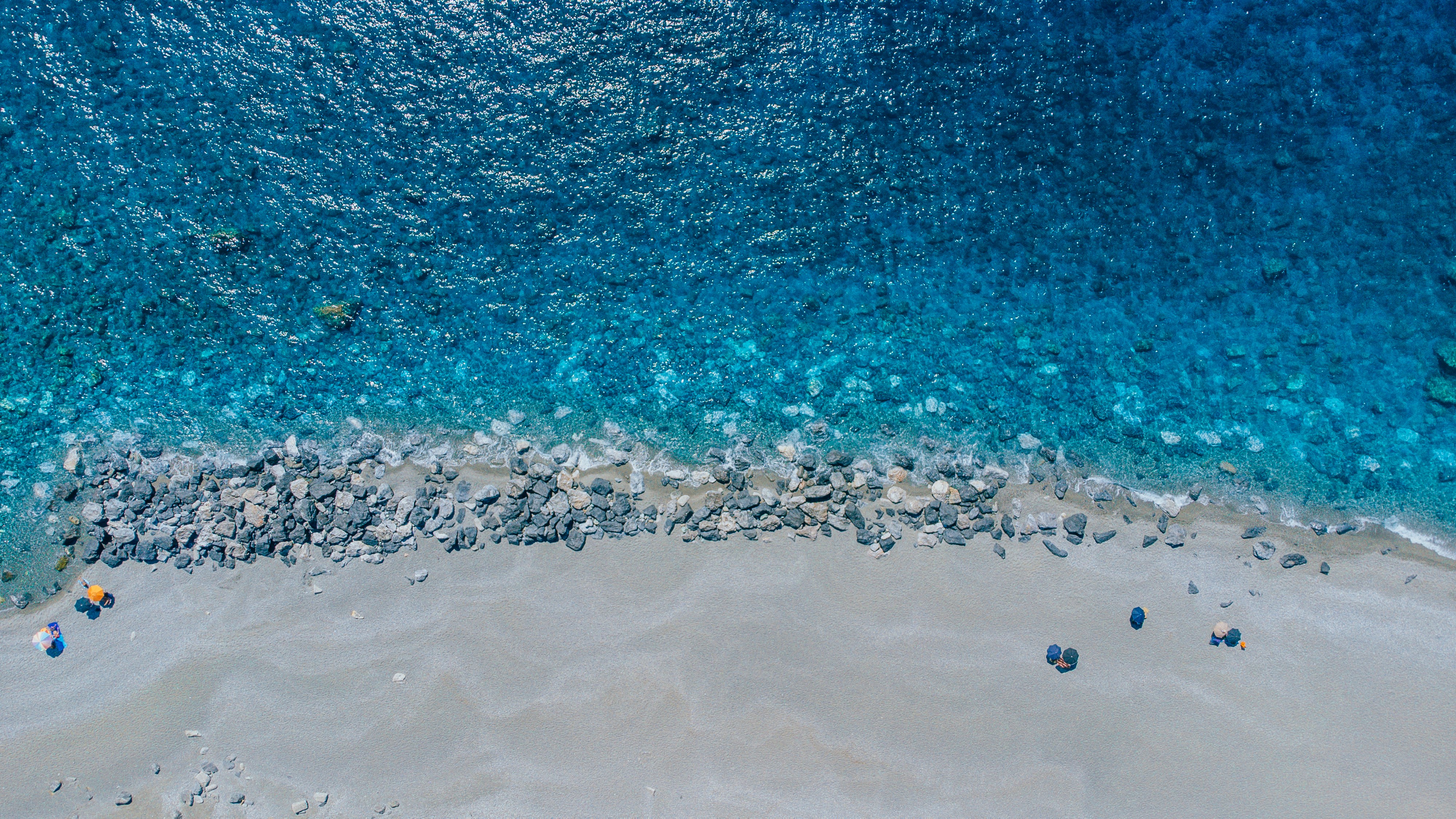 une vue aérienne d’une plage de sable fin et d’une eau bleue