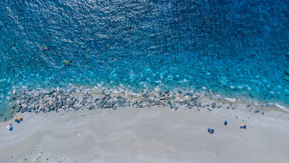an aerial view of a sandy beach and blue water