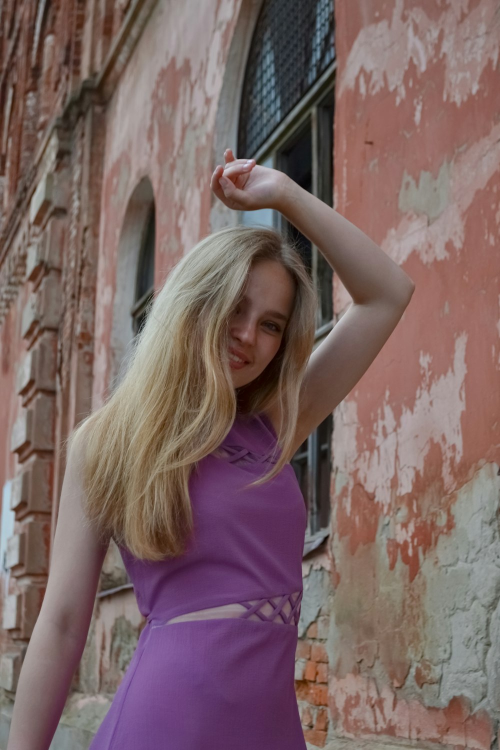 a woman in a purple dress standing in front of a building