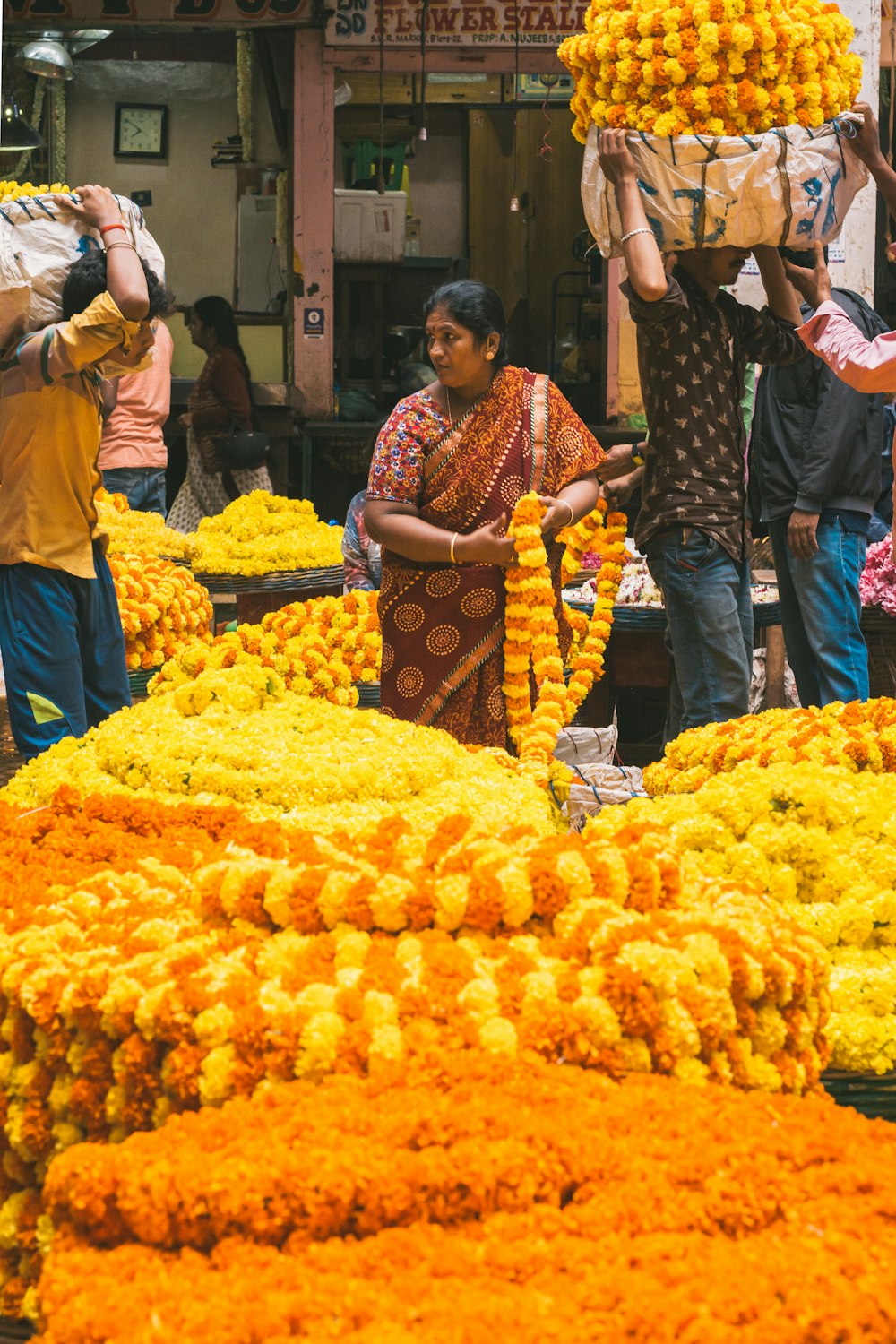 a group of people standing around a bunch of flowers