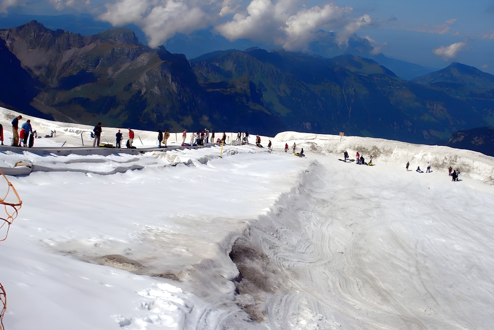 a group of people standing on top of a snow covered slope