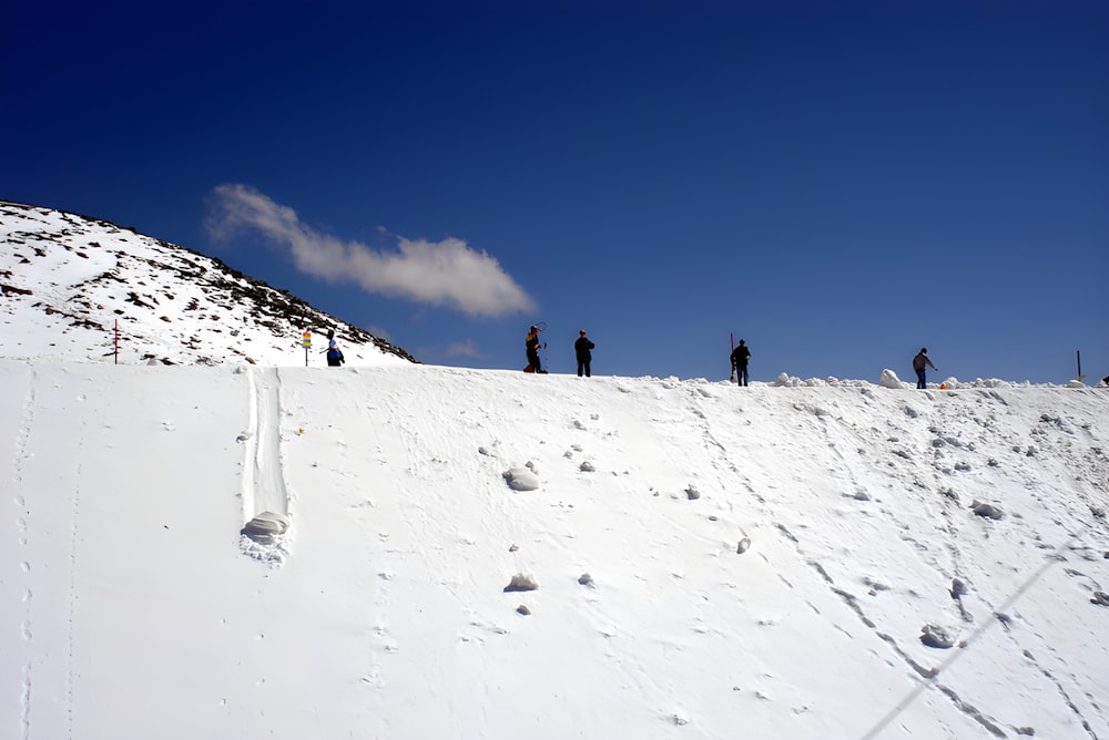 a group of people standing on top of a snow covered slope