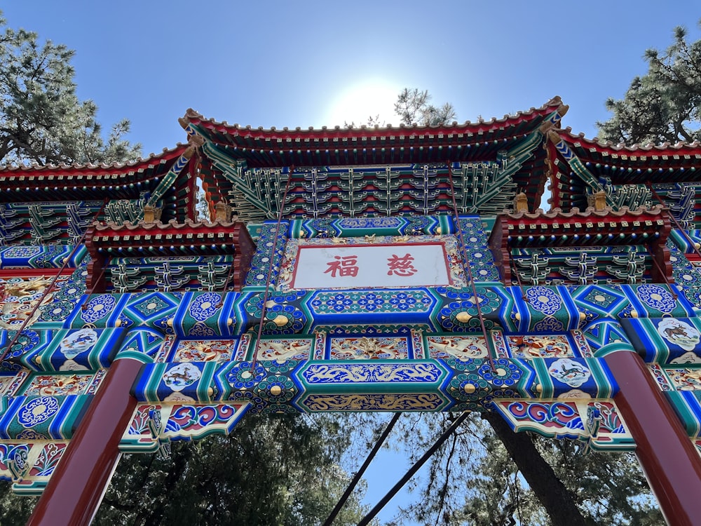 a chinese gate with a sun in the background