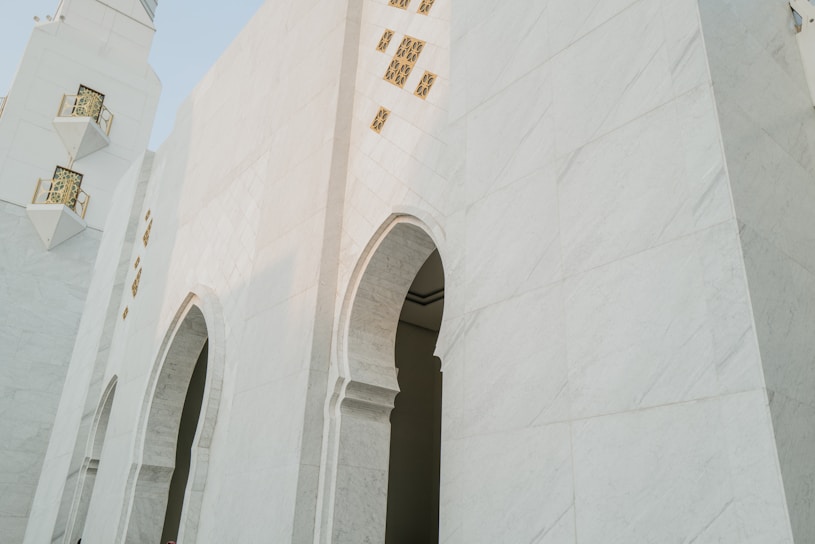 a tall white building with a clock on it's side