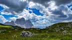 a mountain range under a cloudy blue sky