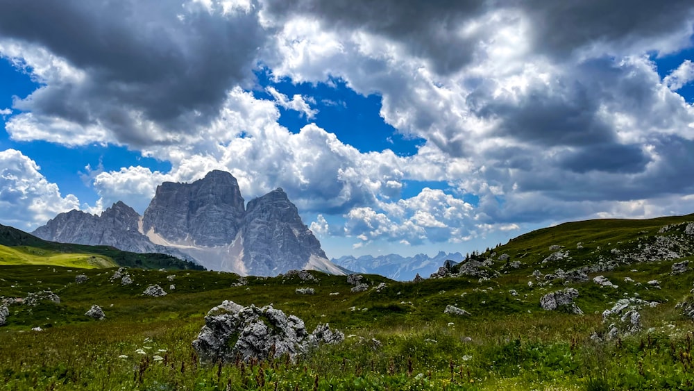 a mountain range under a cloudy blue sky