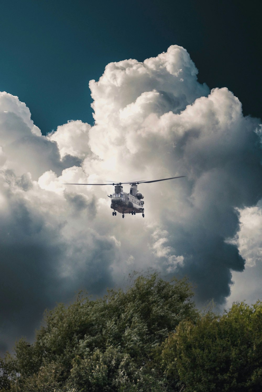 a helicopter flying through a cloudy blue sky