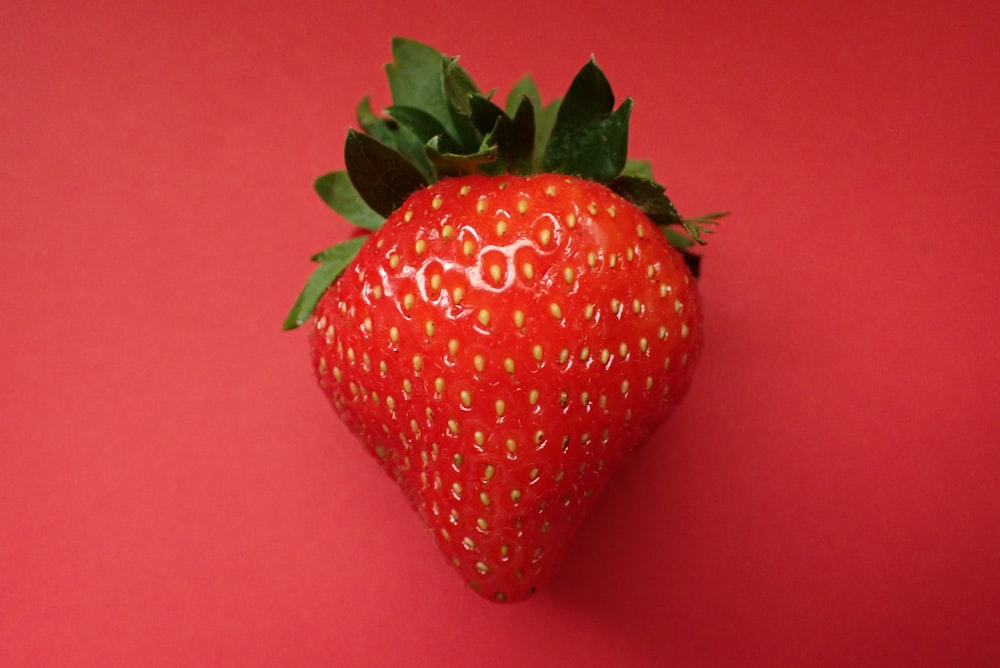 a close up of a strawberry on a red background