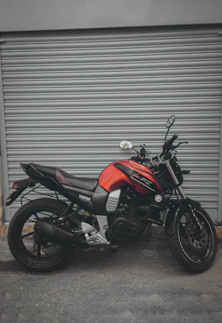 A sleek Yamaha motorcycle parked outside the Incolmotos Yamaha Bogotá showroom with city buildings in the background.
