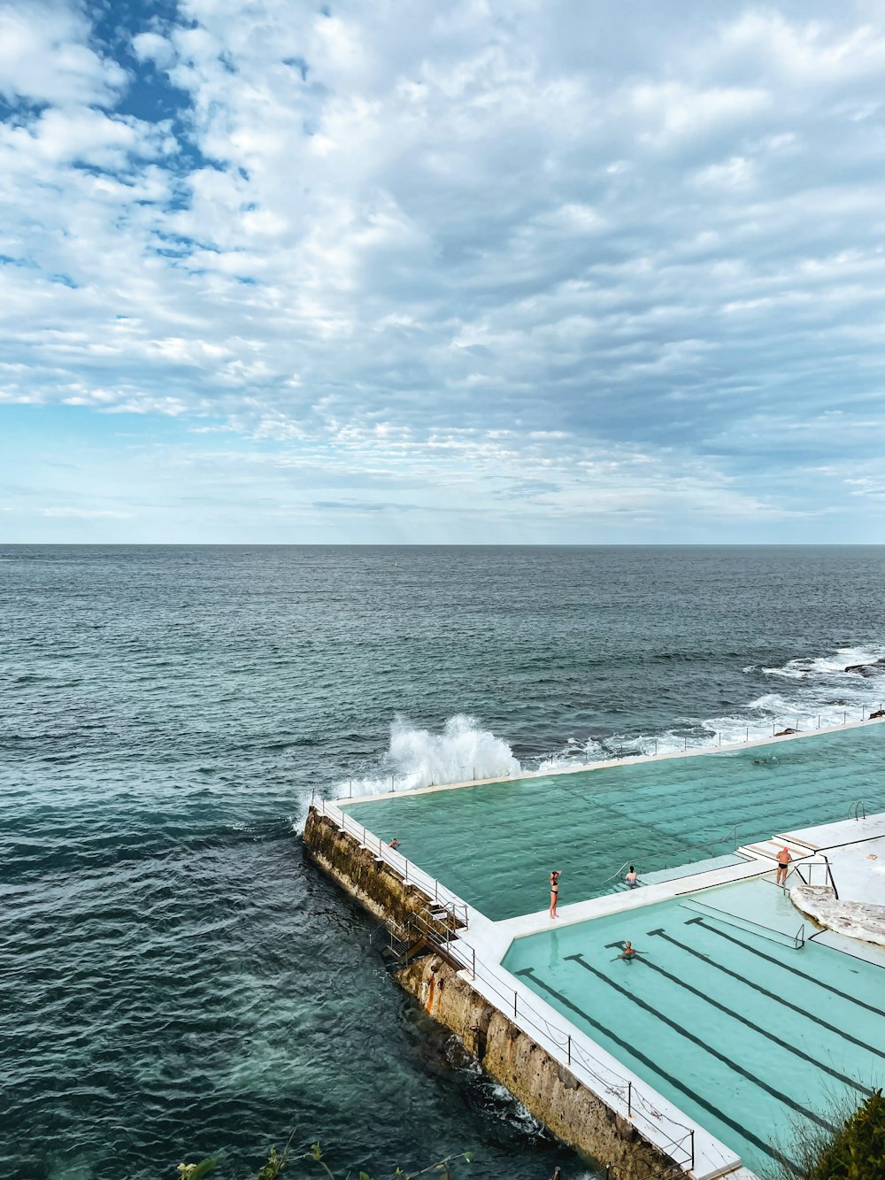 a large swimming pool next to the ocean