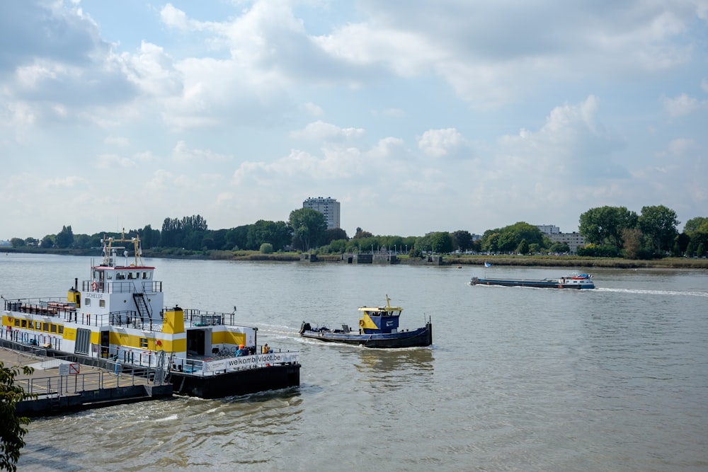 a large boat traveling down a river next to a barge