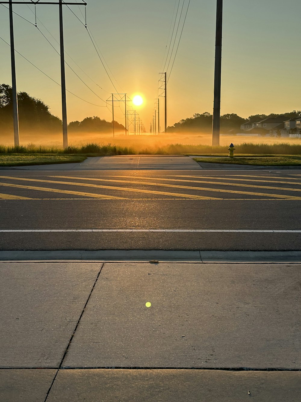 the sun is setting over the empty street