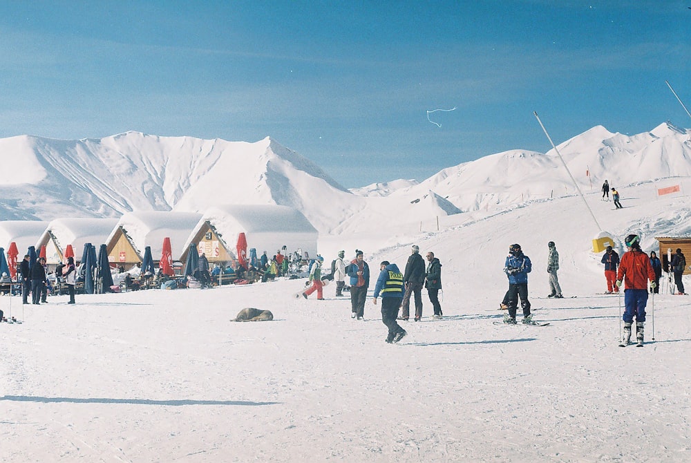 a group of people standing on top of a snow covered slope