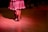 Close-up of dancers' feet moving rhythmically on a wooden stage floor.