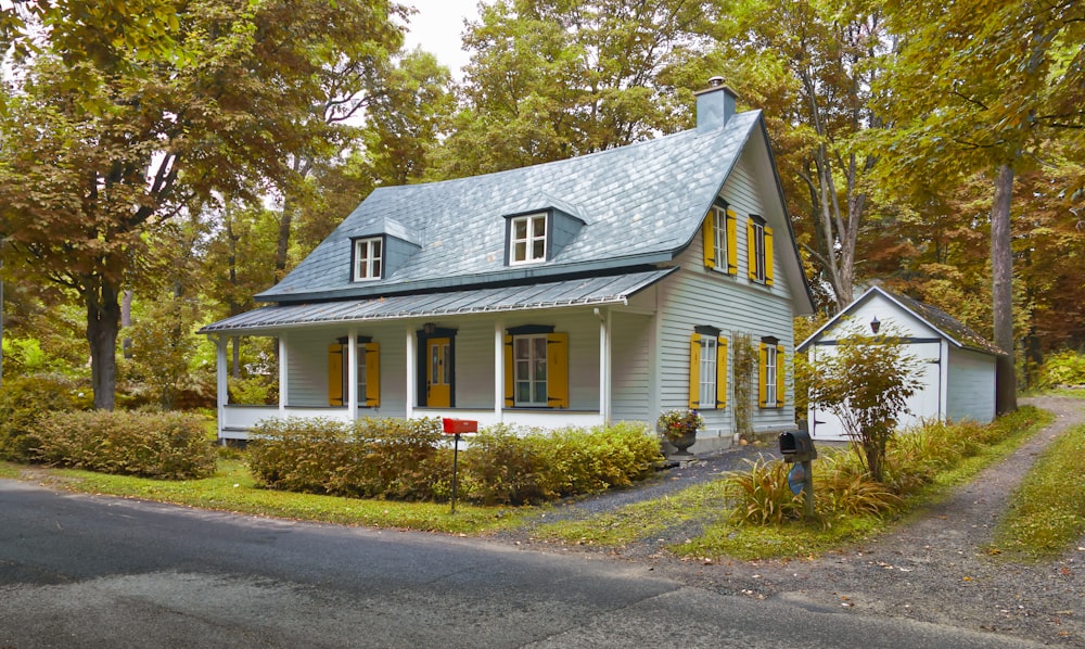 a house with a blue roof and yellow shutters