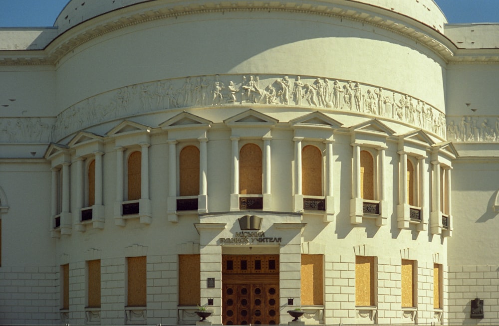 a large white building with a clock on the front of it