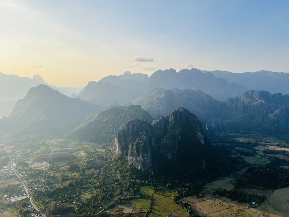 an aerial view of a mountain range with a valley in the foreground