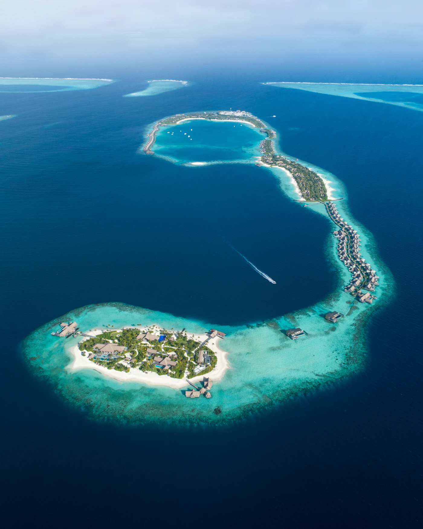 Malediven-Resortinsel aus der Luft mit Lagune und Wasservillen als Ari-Atoll-Reisemotiv