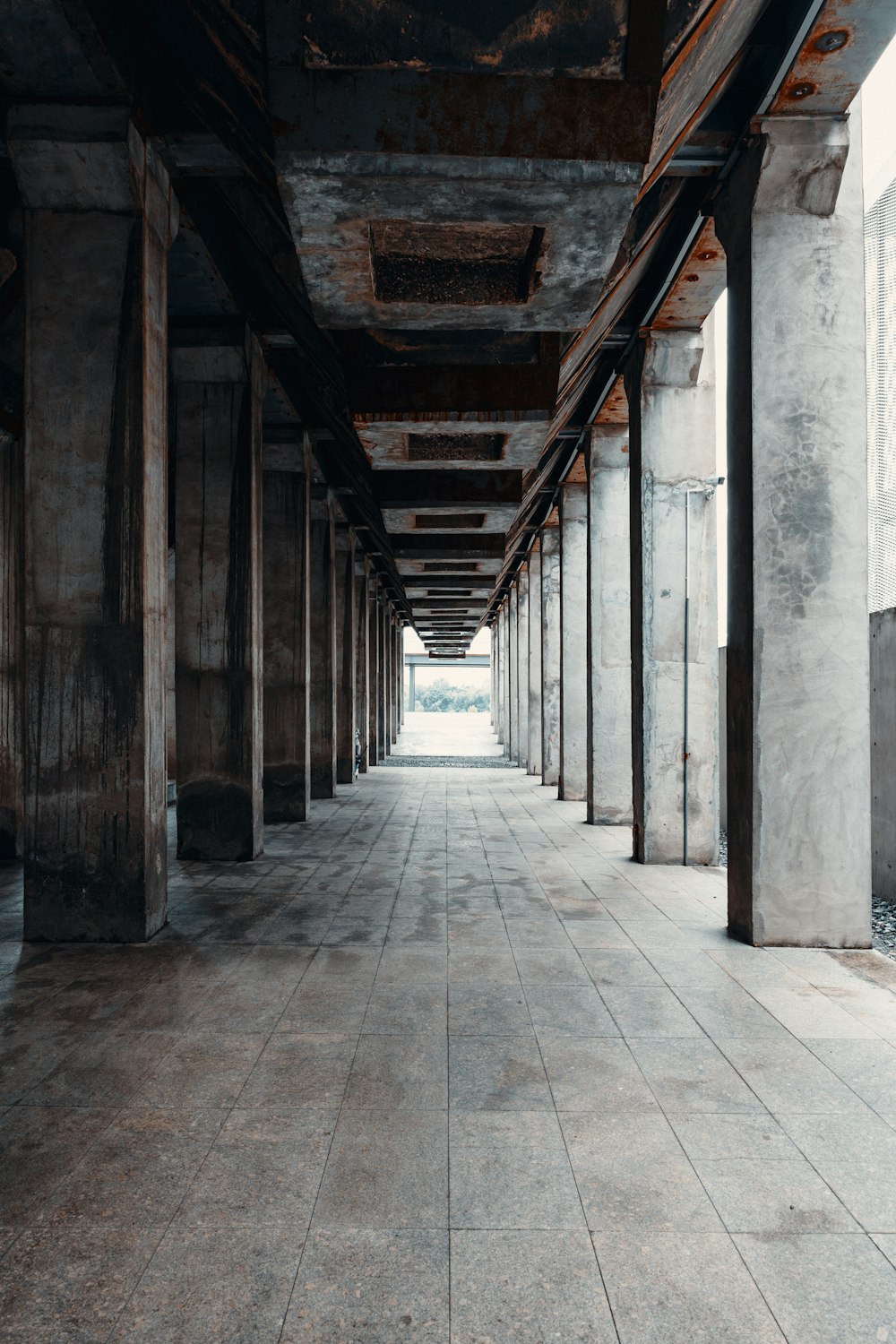 a long hallway with columns and a clock on the wall