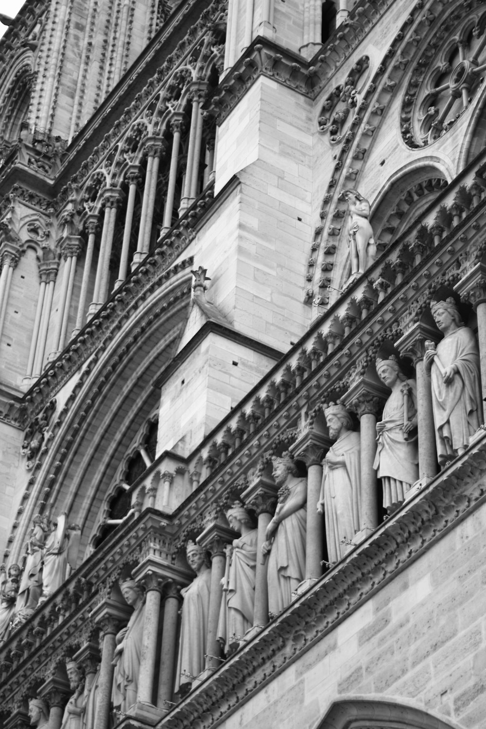 a black and white photo of statues on the side of a building