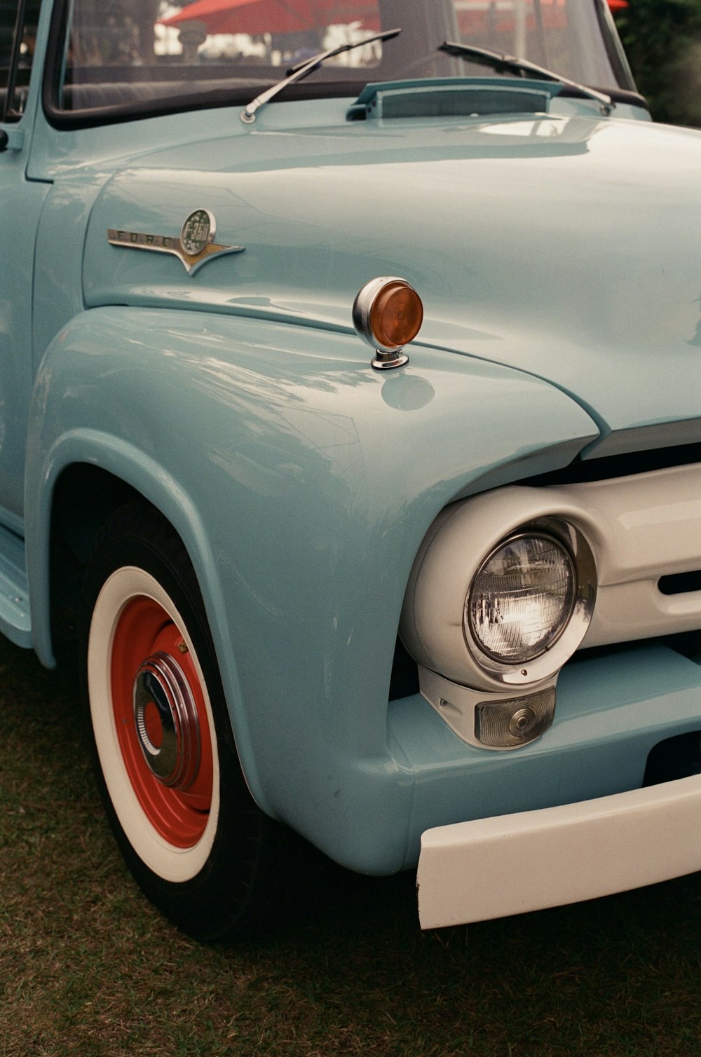 a blue truck parked on top of a grass covered field