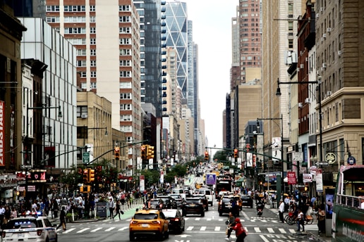 A busy city street with vehicles and people, showcasing urban transportation.