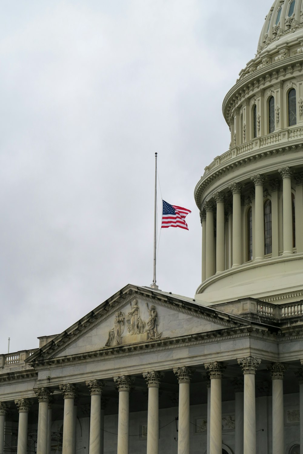 an american flag flying in front of the u s capitol building