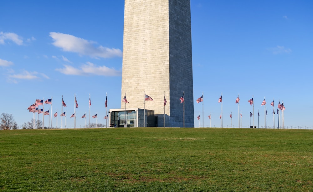 Uma torre alta com muitas bandeiras americanas à sua frente