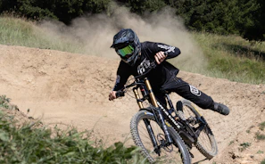 A rider in motion on a pikorida mountain bike, kicking up dirt on a winding path.