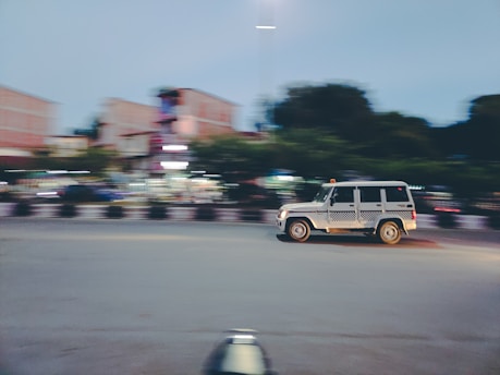 a blurry photo of a jeep driving down a street