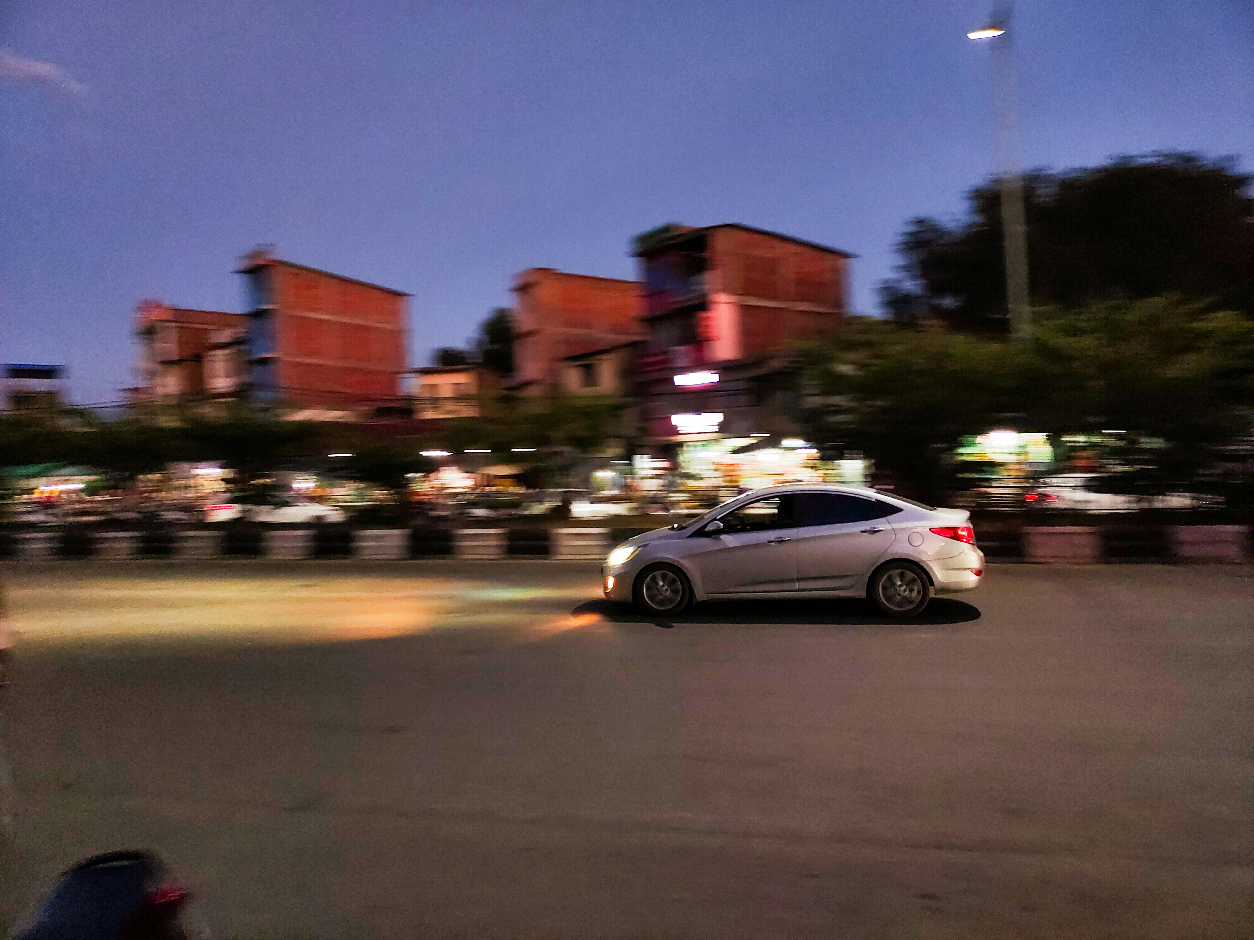Older Tesla Model S driving in an urban setting, representing higher-mileage used cars