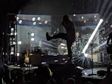 Cinematic shot of juan carlos performing on stage with dramatic lighting.