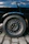Close-up of shiny tires and rims on a black car parked on a city street.