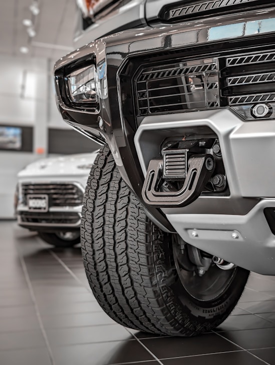 Close-up of a rugged truck grille with shiny chrome accessories under bright sunlight