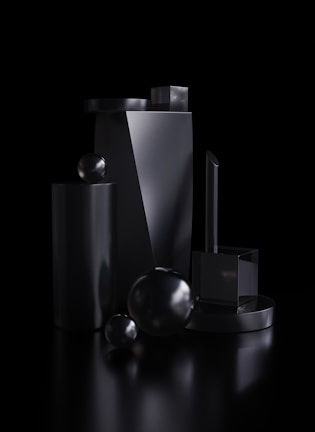 Set of sleek glass objects with smooth curves and glossy surfaces against a pale background.