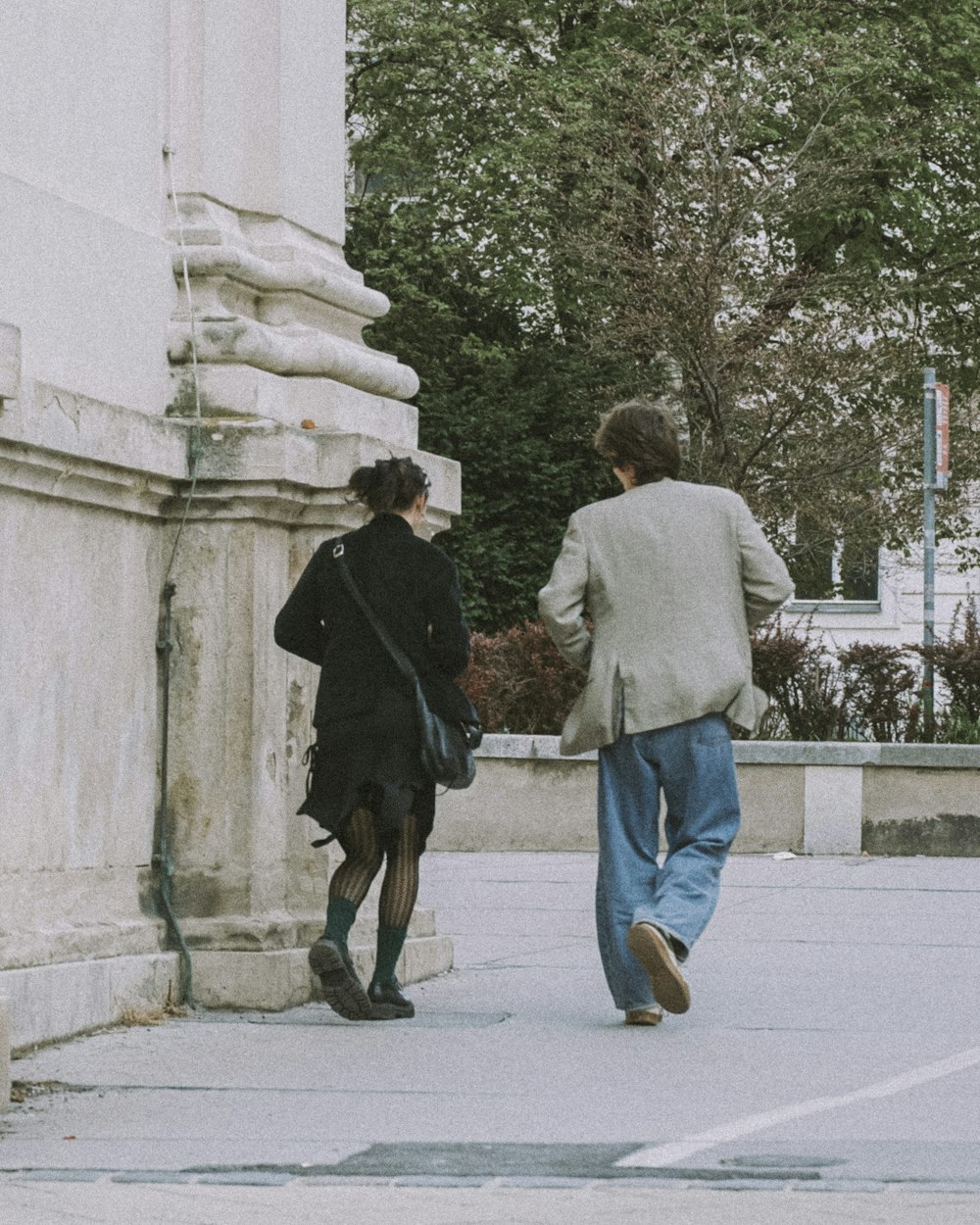 a man and a woman walking down a sidewalk