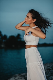 Woman wearing a flowing skirt with gentle folds, standing near Bahia’s coastline at golden hour.