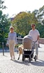 a man and woman walking with a dog in a stroller